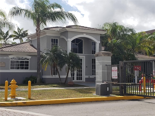 mediterranean / spanish-style home featuring french doors, stucco siding, and a tile roof