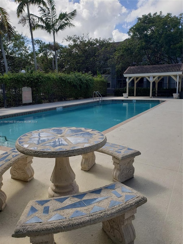 pool featuring a patio, a gazebo, and fence