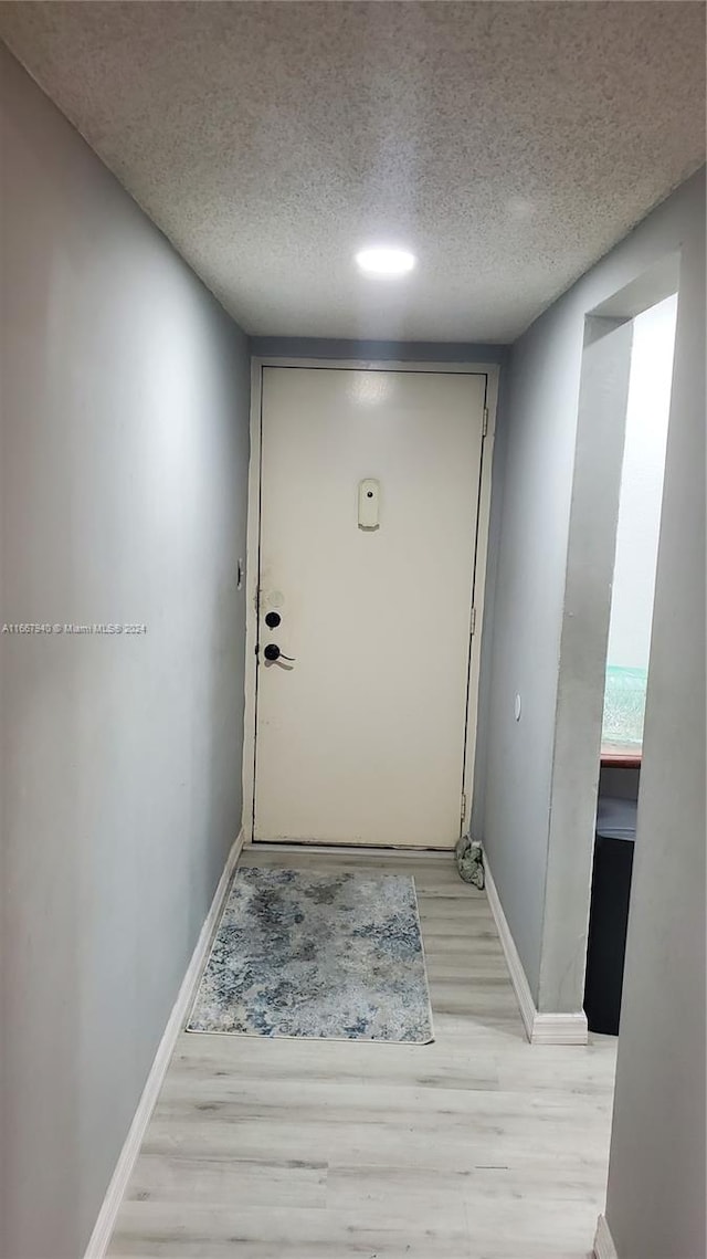 entryway featuring a textured ceiling and light hardwood / wood-style flooring