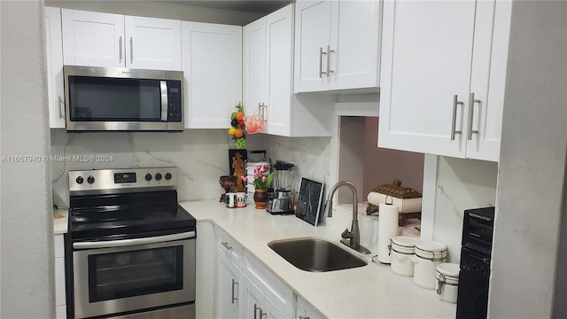 kitchen featuring white cabinets, stainless steel appliances, sink, and decorative backsplash