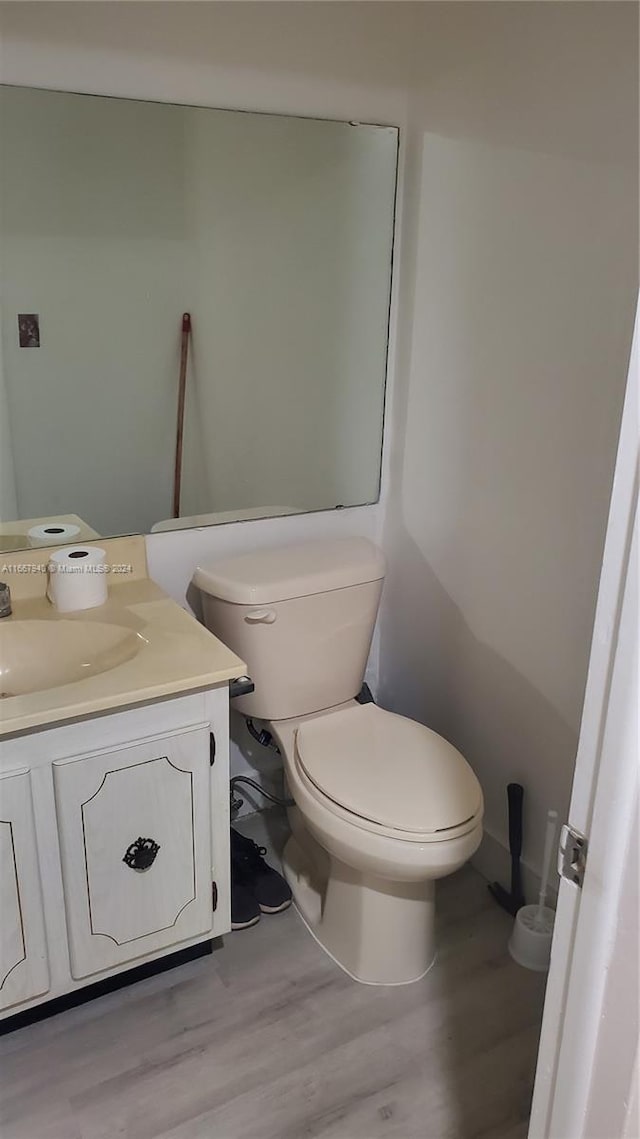 bathroom featuring wood-type flooring, vanity, and toilet