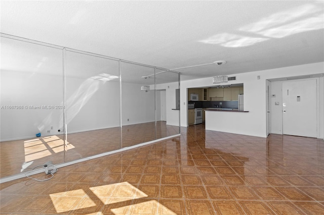 unfurnished living room featuring a textured ceiling