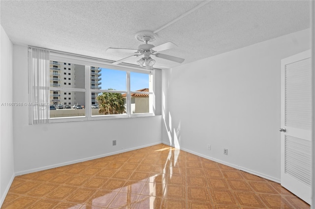 spare room with ceiling fan and a textured ceiling