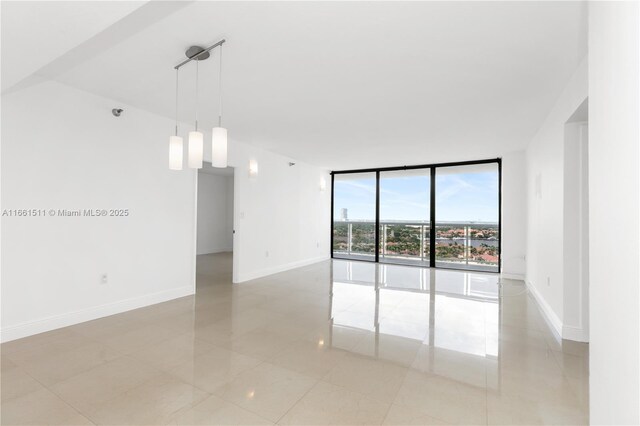 empty room featuring floor to ceiling windows and light tile patterned floors