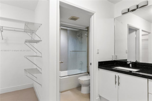 full bathroom with tile patterned floors, toilet, vanity, and combined bath / shower with glass door