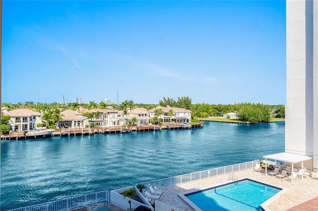 view of swimming pool featuring a patio and a water view