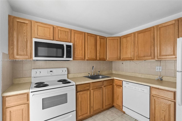 kitchen with light tile patterned flooring, sink, white appliances, and tasteful backsplash