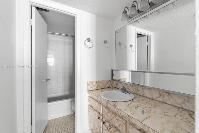 full bathroom with vanity, tiled shower / bath combo, a textured ceiling, tile patterned floors, and toilet