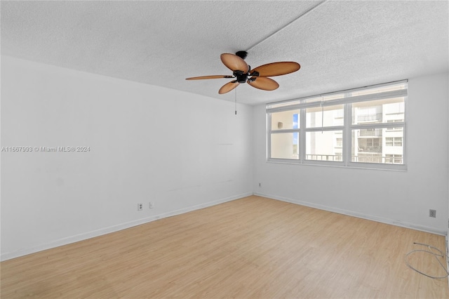 spare room featuring a textured ceiling, ceiling fan, and light hardwood / wood-style flooring