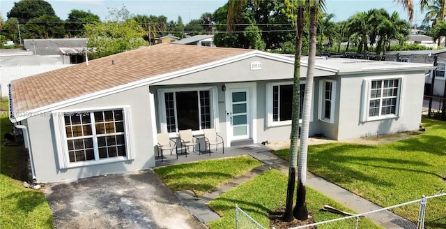 rear view of property featuring a patio and a lawn