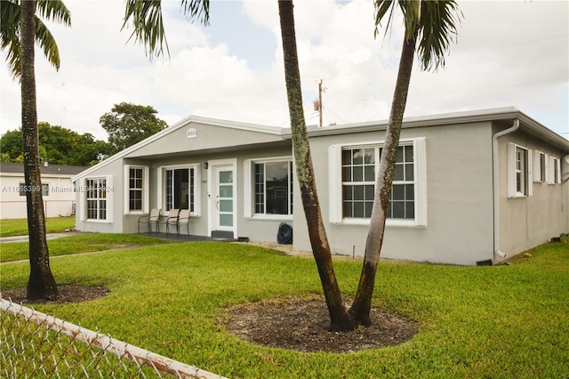 rear view of house featuring a yard