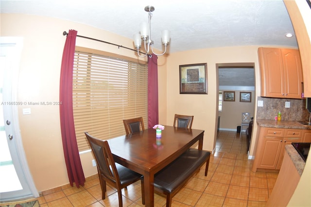 tiled dining room featuring an inviting chandelier