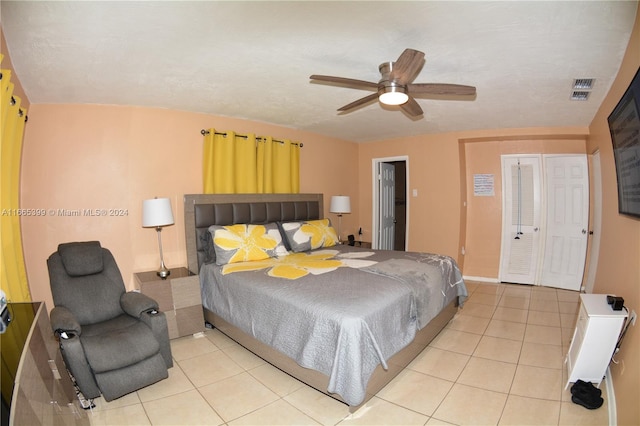 tiled bedroom with ceiling fan and a textured ceiling