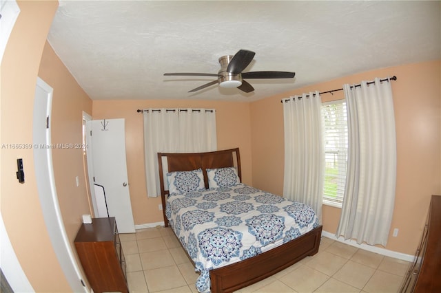 bedroom with ceiling fan, a textured ceiling, multiple windows, and light tile patterned floors