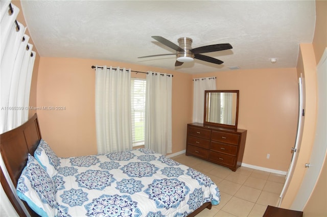 tiled bedroom with a textured ceiling and ceiling fan