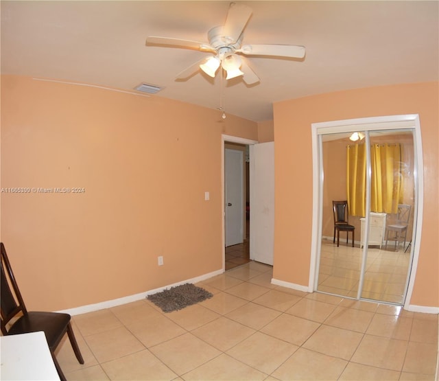 tiled empty room with ceiling fan