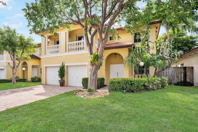 mediterranean / spanish-style house featuring a front yard, a balcony, and a garage