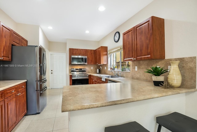 kitchen featuring backsplash, sink, kitchen peninsula, and stainless steel appliances