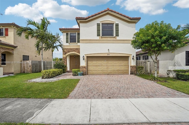 mediterranean / spanish-style house with a garage, stone siding, fence, decorative driveway, and stucco siding