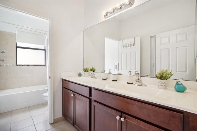 bathroom featuring toilet, tile patterned flooring, double vanity, and a sink