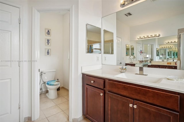 bathroom with toilet, vanity, visible vents, tile patterned floors, and a stall shower