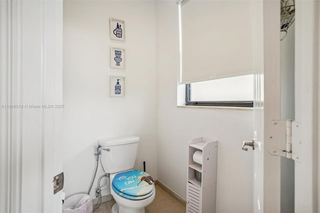 bathroom featuring toilet, tile patterned flooring, and baseboards