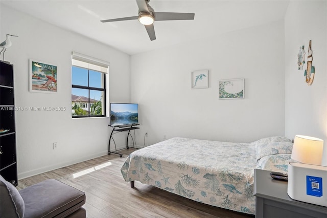 bedroom featuring a ceiling fan, baseboards, and wood finished floors