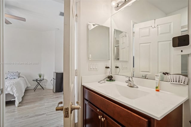 bathroom with visible vents, ensuite bathroom, wood finished floors, and vanity