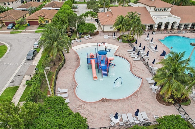 pool with a residential view, a water play area, and playground community