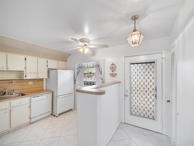 kitchen with pendant lighting, white appliances, light tile patterned floors, and sink