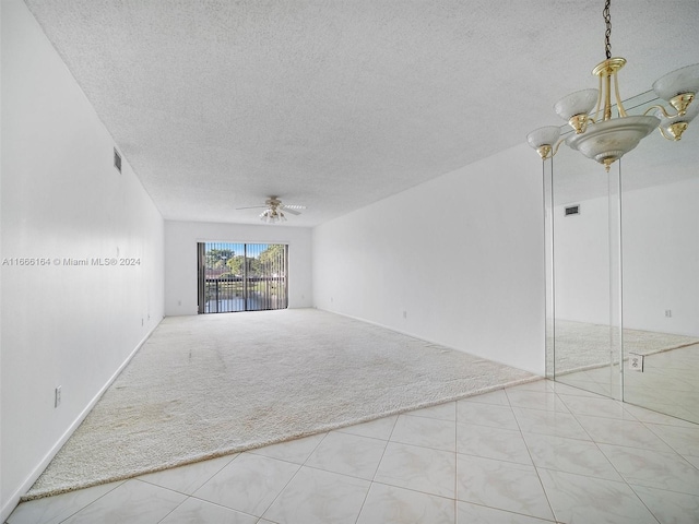 carpeted spare room featuring ceiling fan and a textured ceiling