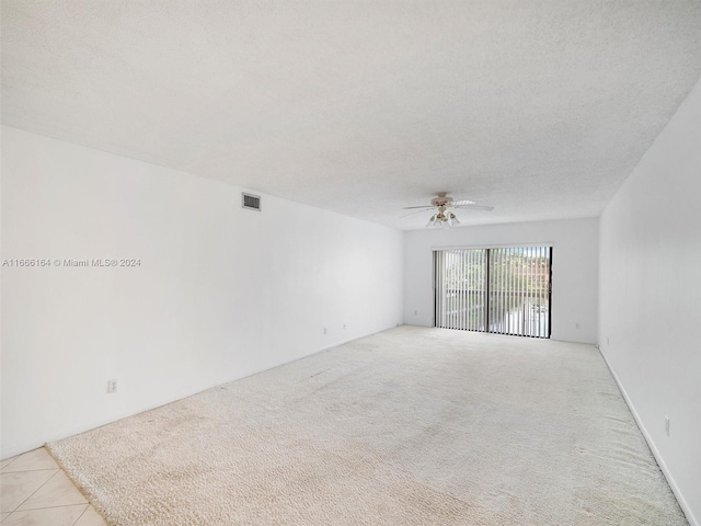 carpeted spare room featuring a textured ceiling and ceiling fan