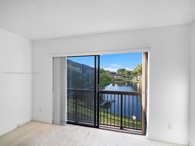 carpeted spare room with a textured ceiling and a water view