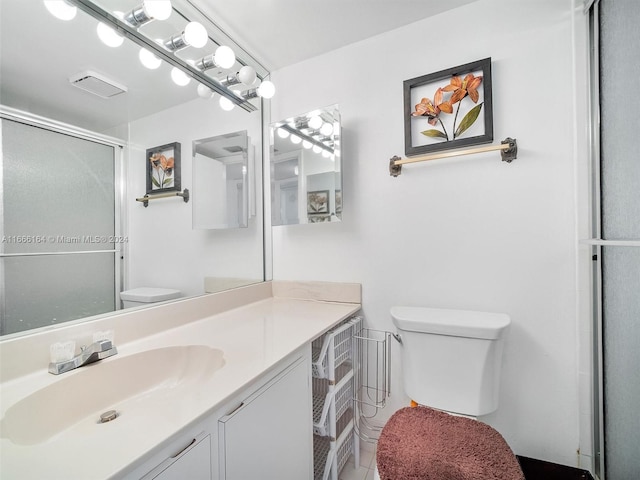 bathroom with vanity, tile patterned flooring, toilet, and a shower with door