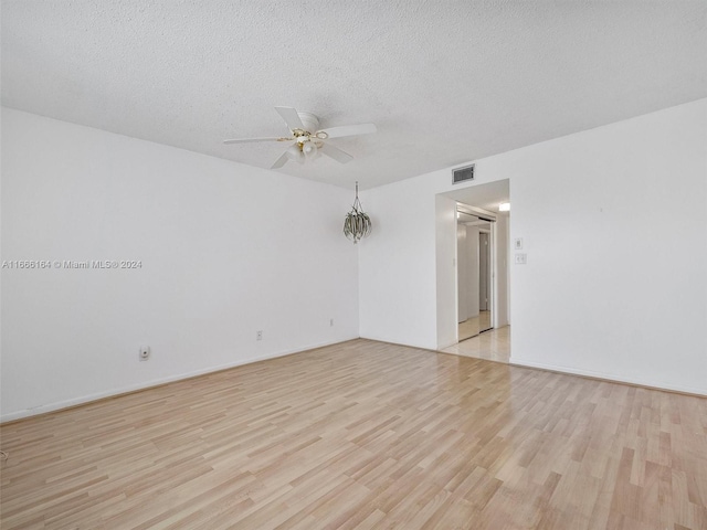 unfurnished room featuring a textured ceiling, light hardwood / wood-style floors, and ceiling fan