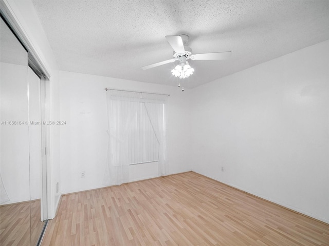 unfurnished bedroom featuring ceiling fan, a textured ceiling, and light wood-type flooring