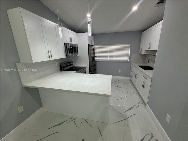 kitchen featuring appliances with stainless steel finishes, white cabinets, kitchen peninsula, decorative light fixtures, and sink