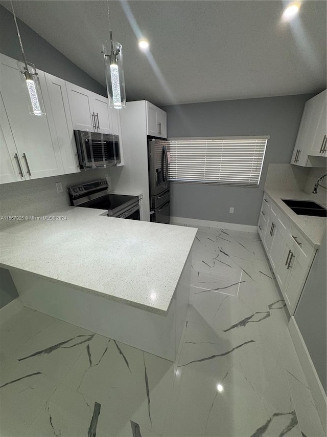 kitchen featuring appliances with stainless steel finishes, hanging light fixtures, white cabinetry, and sink