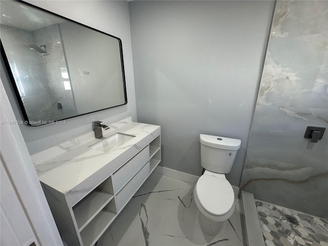 bathroom featuring a tile shower, vanity, and toilet