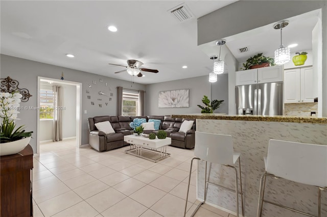 living room with vaulted ceiling, ceiling fan, and light tile patterned flooring