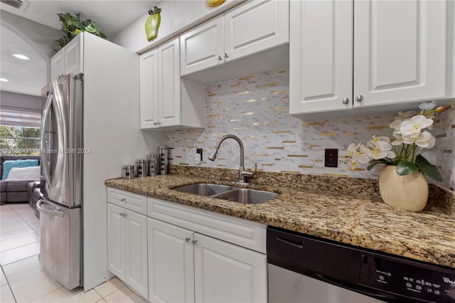 kitchen featuring white cabinets, light tile patterned floors, sink, stainless steel appliances, and dark stone counters