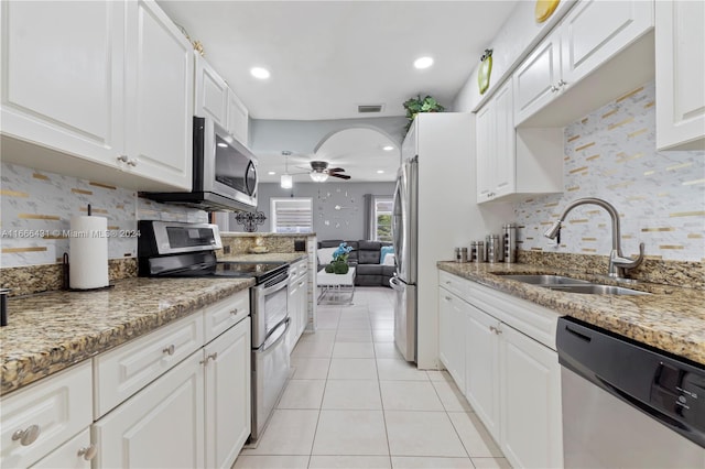 kitchen featuring light stone countertops, stainless steel appliances, sink, and white cabinetry