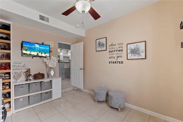 living area with ceiling fan and light tile patterned floors