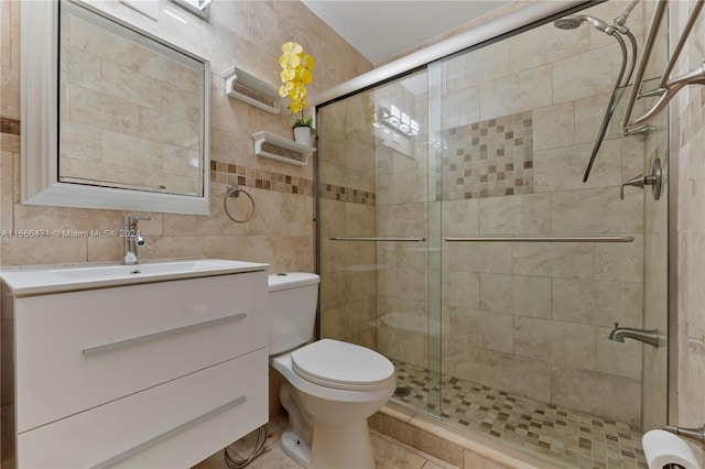 bathroom with tile walls, tasteful backsplash, a shower with shower door, vanity, and toilet