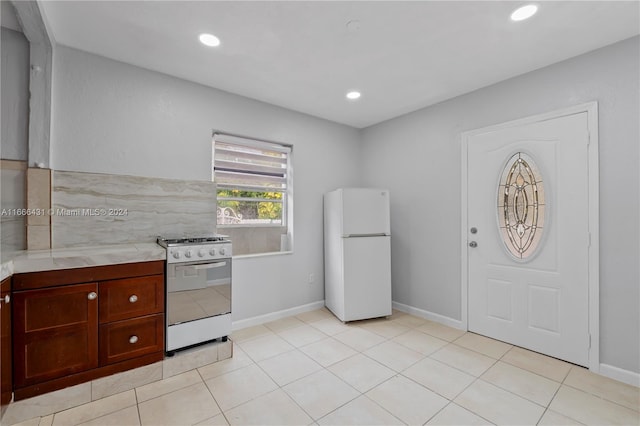 kitchen with light tile patterned flooring and white appliances