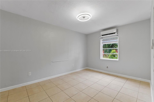 empty room featuring light tile patterned floors and a wall mounted air conditioner