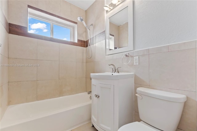 full bathroom featuring tile walls, vanity, toilet, and tiled shower / bath