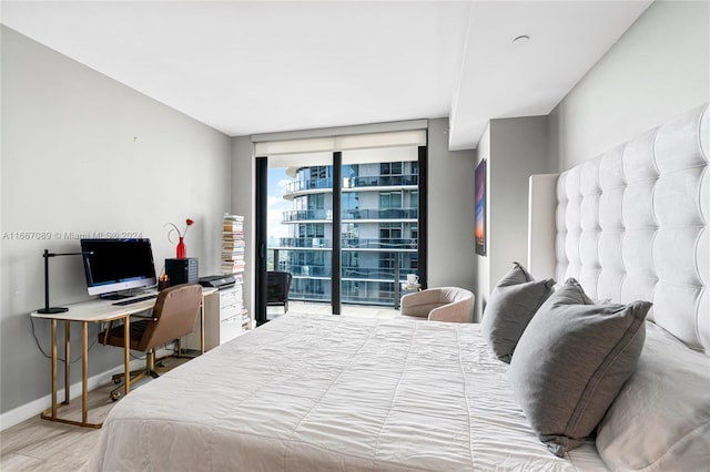 bedroom featuring expansive windows and hardwood / wood-style floors