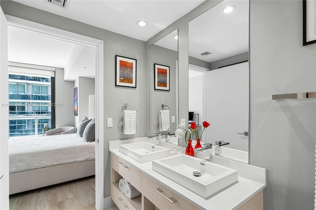 45 SW 9th St Unit 4007, Miami, FL 33130 - ensuite bathroom featuring double vanity, recessed lighting, and wood finished floors