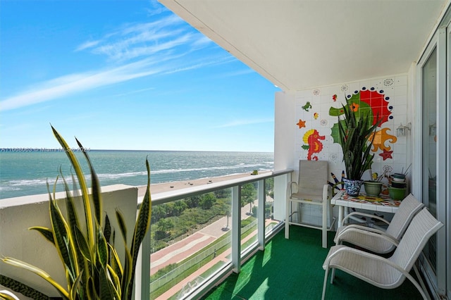 balcony featuring a beach view and a water view